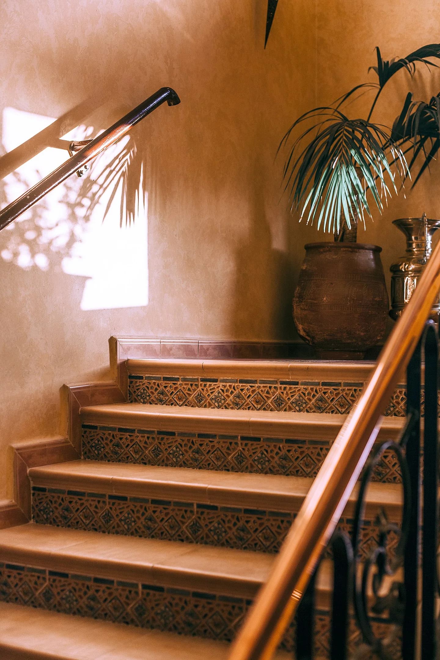 Escalier en terre cuite et ombre de palmier sur un mur